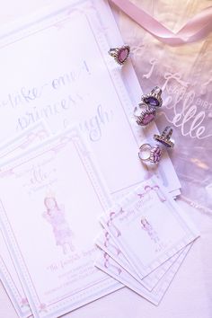 there are three rings on top of the wedding card and two other items next to it