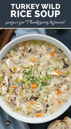 a white bowl filled with turkey wild rice soup on top of a blue napkin and two pieces of bread