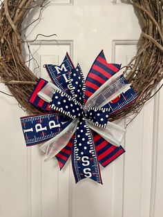 a red, white and blue patriotic wreath with measuring tape on it hanging on a door