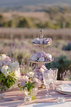 the table is set with pink and white flowers, candles, plates and silverware