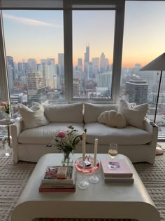 a living room filled with furniture and a large window covered in lots of windows overlooking the city