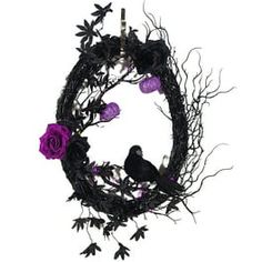 a black wreath with purple flowers and two birds on the branches, hanging from a white wall