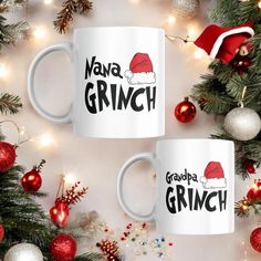 two white coffee mugs with santa hats on them