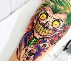 a joker tattoo on the arm with yellow eyes