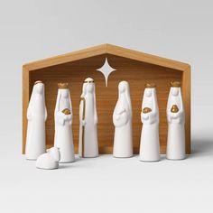 a group of white figurines standing next to each other in front of a wooden box