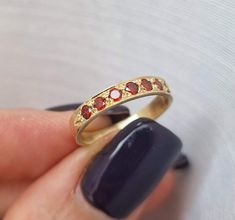 Dainty half-eternity solid gold ring set with 7 garnet gems, stacked gemstone ring jewelry for women, available in 9k yellow gold, 14k yellow, white, or rose gold, and 18k yellow gold. This delicate handmade solid gold ring is set with seven red garnet gems. It has a vintage style design, but the red and gold combination gives it a timeless style. It is available in 9k yellow gold, 14k yellow, white, or rose gold, and 18k yellow gold. This beautiful gold ring is romantic and feminine. It will lo Gold Ruby Half Eternity Round Cut Ring, 14k Gold Ruby Half Eternity Ring, Yellow Gold Ruby Half Eternity Promise Ring, 14k Gold Eternity Band With Rose Cut Diamonds Gift, 14k Gold Ruby Ring With Half Eternity Design, Garnet Gold Ring, Beautiful Gold Rings, Dainty Gold Ring, Dainty Gold Rings