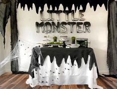 the table is decorated with black and white decorations, spider webs, and balloons