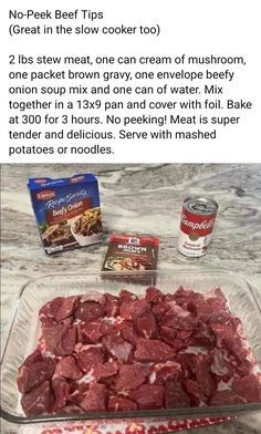 a glass dish filled with meat sitting on top of a counter next to two cans of food