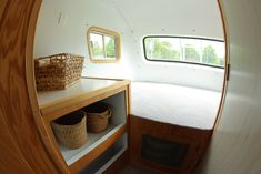 the inside of a small boat with baskets on it's shelf and shelves below