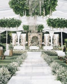 an outdoor wedding setup with white linens and greenery