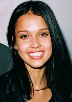 a close up of a person with long black hair and a smile on her face