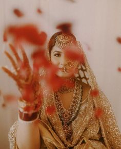 a woman dressed in gold and holding her hands up