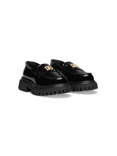 jet black leather patent finish appliqué logo whipstitch detailing almond toe slip-on style branded leather insole ridged rubber sole Classic Loafers With Studded Rubber Outsoles, Classic Loafers With Studded Rubber Outsoles And Round Toe, Designer Slip-ons With Rubber Sole And Round Toe, Black Patent Leather Loafers With Rubber Sole, Black Patent Leather Loafers With Textured Sole, Classic Patent Leather Loafers With Lug Sole, Luxury Patent Leather Loafers With Textured Sole, Luxury Black Slip-ons With Round Toe, Patent Leather Loafers With Textured Sole And Round Toe