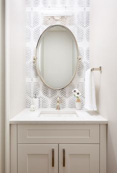 a bathroom vanity with a round mirror above it