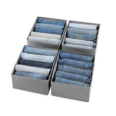 six pairs of denim pants are stacked in a storage box on top of each other