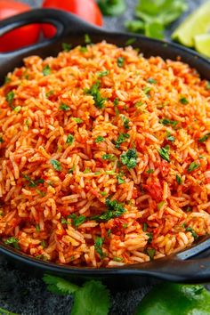 mexican rice in a skillet with tomatoes and lettuce on the side, ready to be eaten