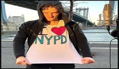 a man in a hoodie holding up a t - shirt with the word nypd printed on it