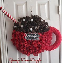 a wreath is hanging on the front door with candy canes and pine cones in it