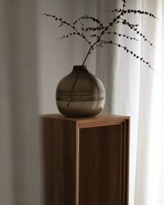 a vase sitting on top of a wooden cabinet