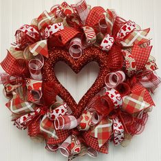 a red and white heart shaped wreath hanging on a door