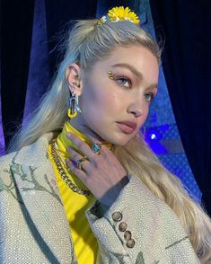 a woman with long blonde hair wearing yellow jewelry