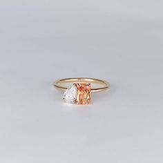 an orange and white diamond ring sitting on top of a table