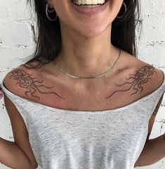 a woman with tattoos on her chest smiling