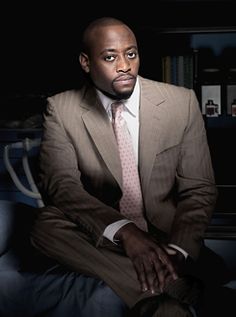 a man in a suit and tie sitting on a couch