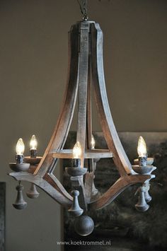 a wooden chandelier with five candles on the bottom and one light in the middle