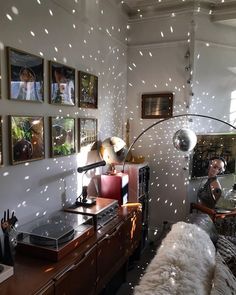 a living room filled with furniture and pictures hanging on the wall next to a desk