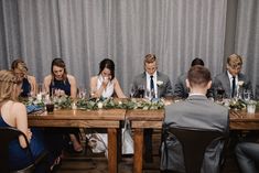 a group of people sitting around a wooden table