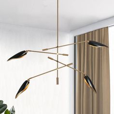 a modern chandelier with three lights hanging from it's sides in a living room