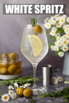 white spritz in a wine glass with lemons and rosemary garnish