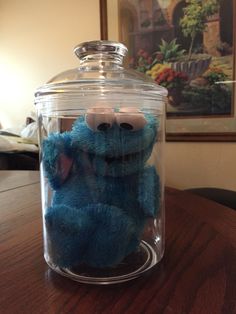 a blue stuffed animal in a glass jar