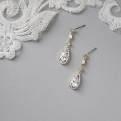 Enhance your bridal ensemble with these exquisite wedding earrings featuring a pave set elongated pear drop, delicately suspended from petite round and marquise CZ stones.They are 1.5 inches long, post pierced backs, rhodium, rose gold or gold plated, grade AAA CZ stones, lead, cadmium, and nickel free. Gold Teardrop Earrings With Diamond Accents For Wedding, Pear-shaped Teardrop Earrings With Diamond Accents For Wedding, Classic Cubic Zirconia Linear Earrings For Wedding, Classic Teardrop Linear Earrings For Wedding, Elegant Linear Earrings With Sparkling Stones For Wedding, Elegant Linear Earrings With Diamond Accents For Wedding, Wedding Drop Earrings With Diamond Accents, Elegant Wedding Linear Earrings With Diamond Accents, Wedding Long Drop Linear Earrings With Diamond Accents