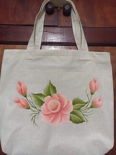 a white bag with pink flowers painted on it