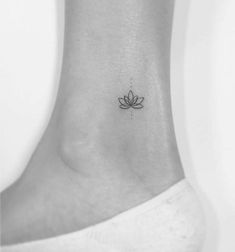 a small lotus tattoo on the ankle