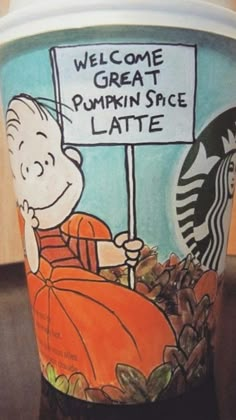 a starbucks cup with a cartoon character holding a sign that says welcome great pumpkin spice latte