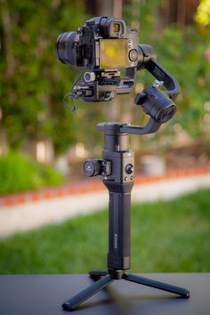 a tripod with a camera attached to it sitting on top of a table outside