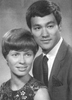 an old black and white photo of two people posing for the camera with their arms around each other