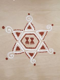 an intricately designed piece of wood with red and white designs on it