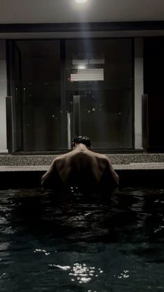 a man is in the water with his back turned to the camera and head down