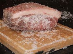 a piece of meat sitting on top of a cutting board covered in powdered sugar