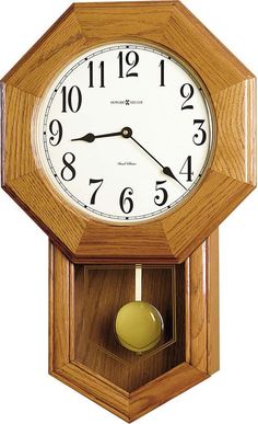 a wooden clock with white face and numbers on the front is attached to a wall