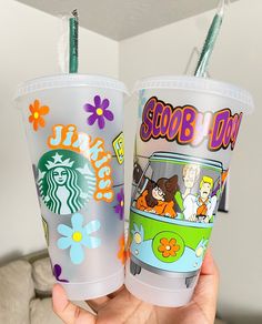 two starbucks cups with cartoon characters on them