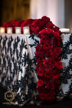 the table is decorated with red roses and black lace for an elegant touch to the centerpiece