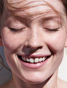 a close up of a person smiling with their eyes closed