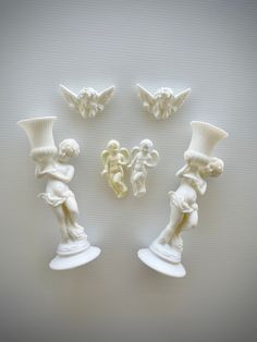 four white vases with angels and cherubs on them