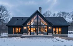 a house that is in the snow with lots of lights on it's windows