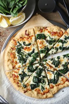 a pizza with spinach and cheese cut into slices